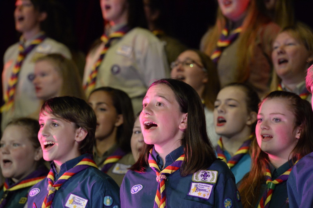 A group of Scouts singing on stage.
